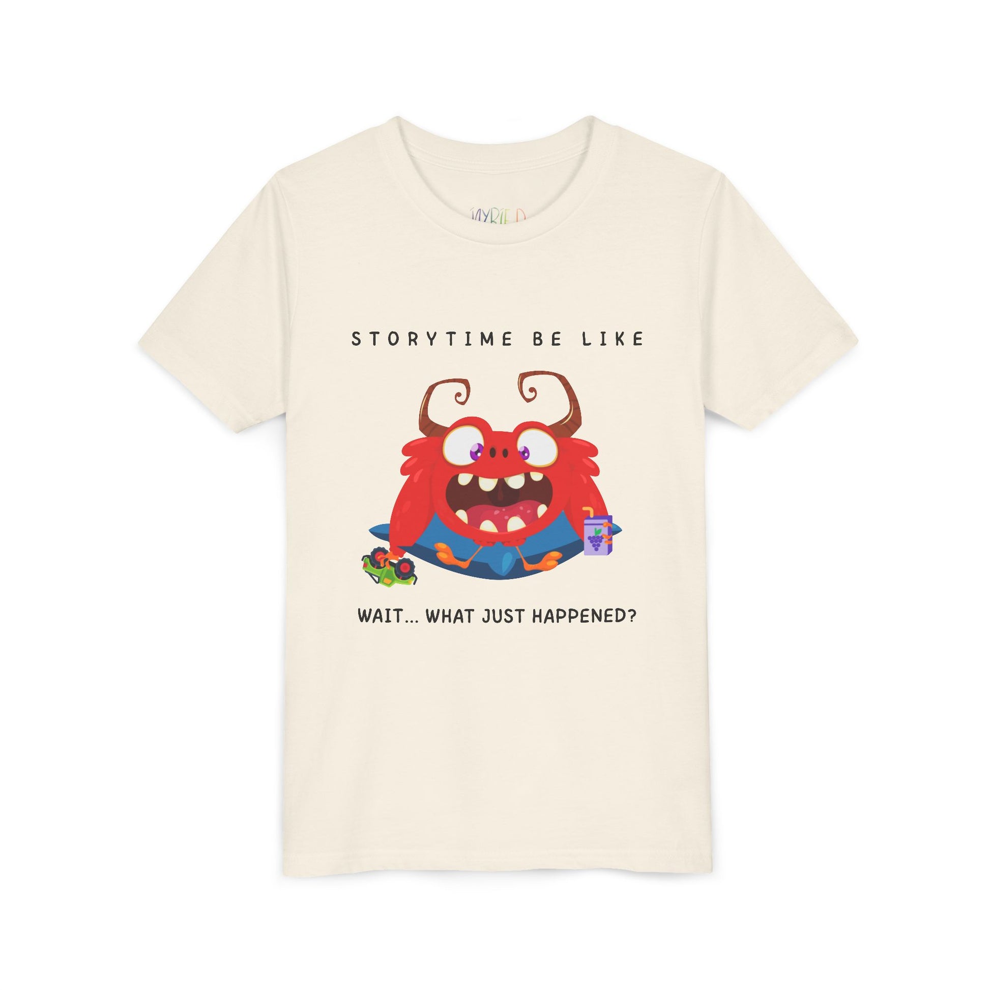 Beige t-shirt with a bewildered cartoon monster graphic sitting on a pillow, holding a car toy and a juice box, text 'Storytime be like wait...what just happened?'