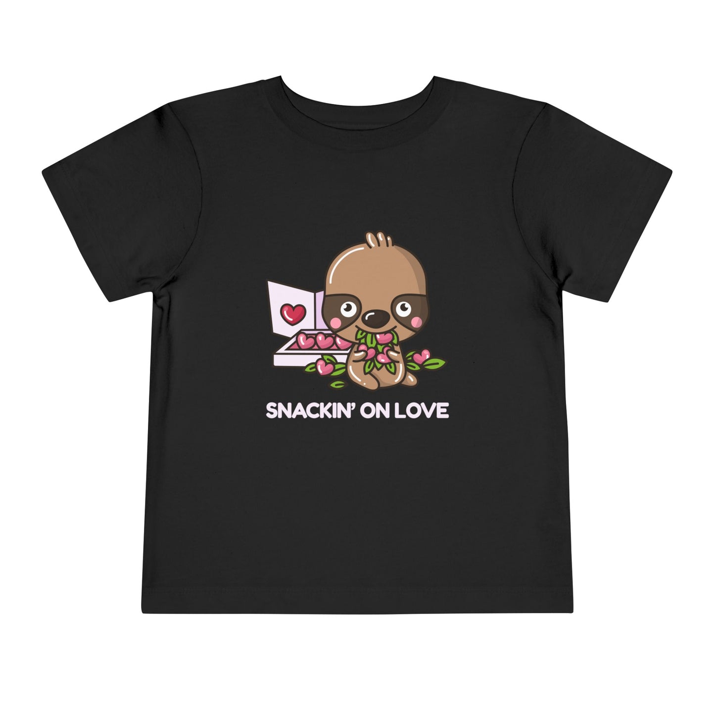 Black toddler t-shirt with a cartoon eating a box of heart shaped candies, text 'SNACKIN' ON LOVE'