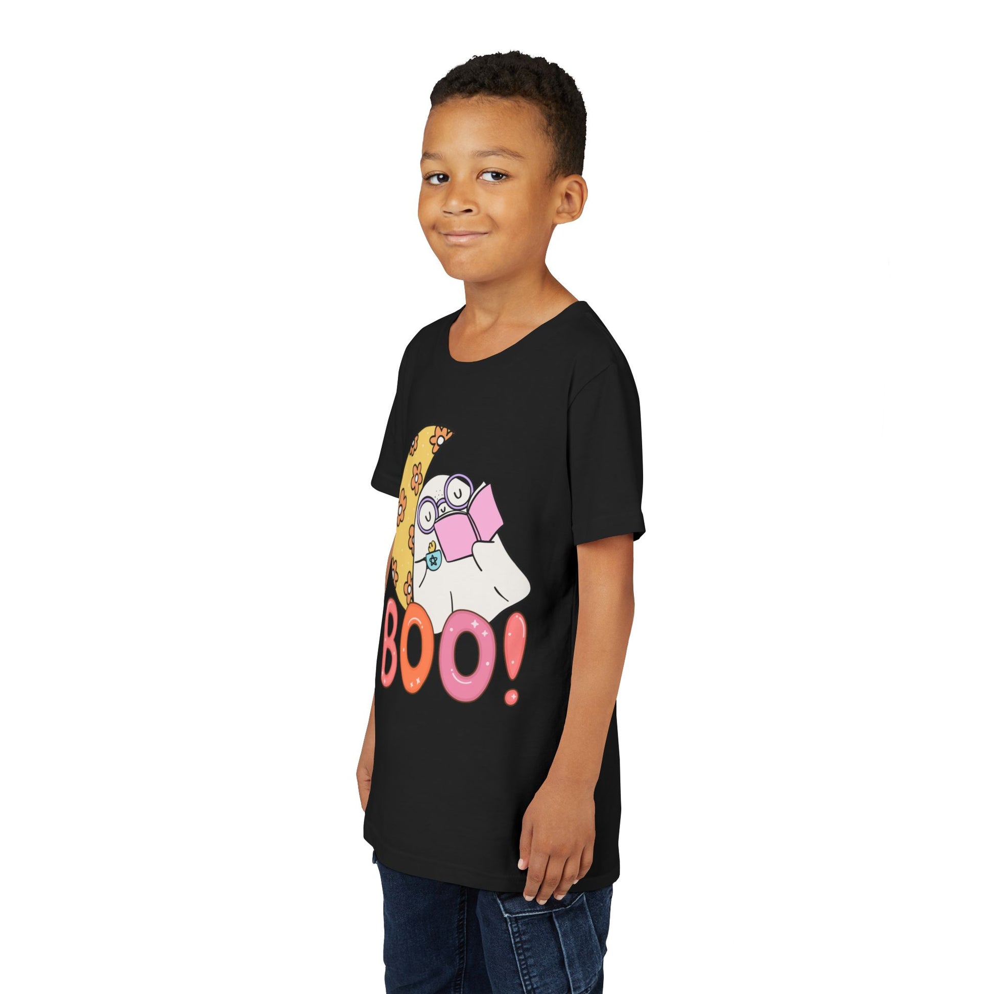 Boy wearing a black t-shirt with a cartoon ghost leaning on a crescent flowered moon with a hot beverage and a good book, text 'BOO!' in large letters 