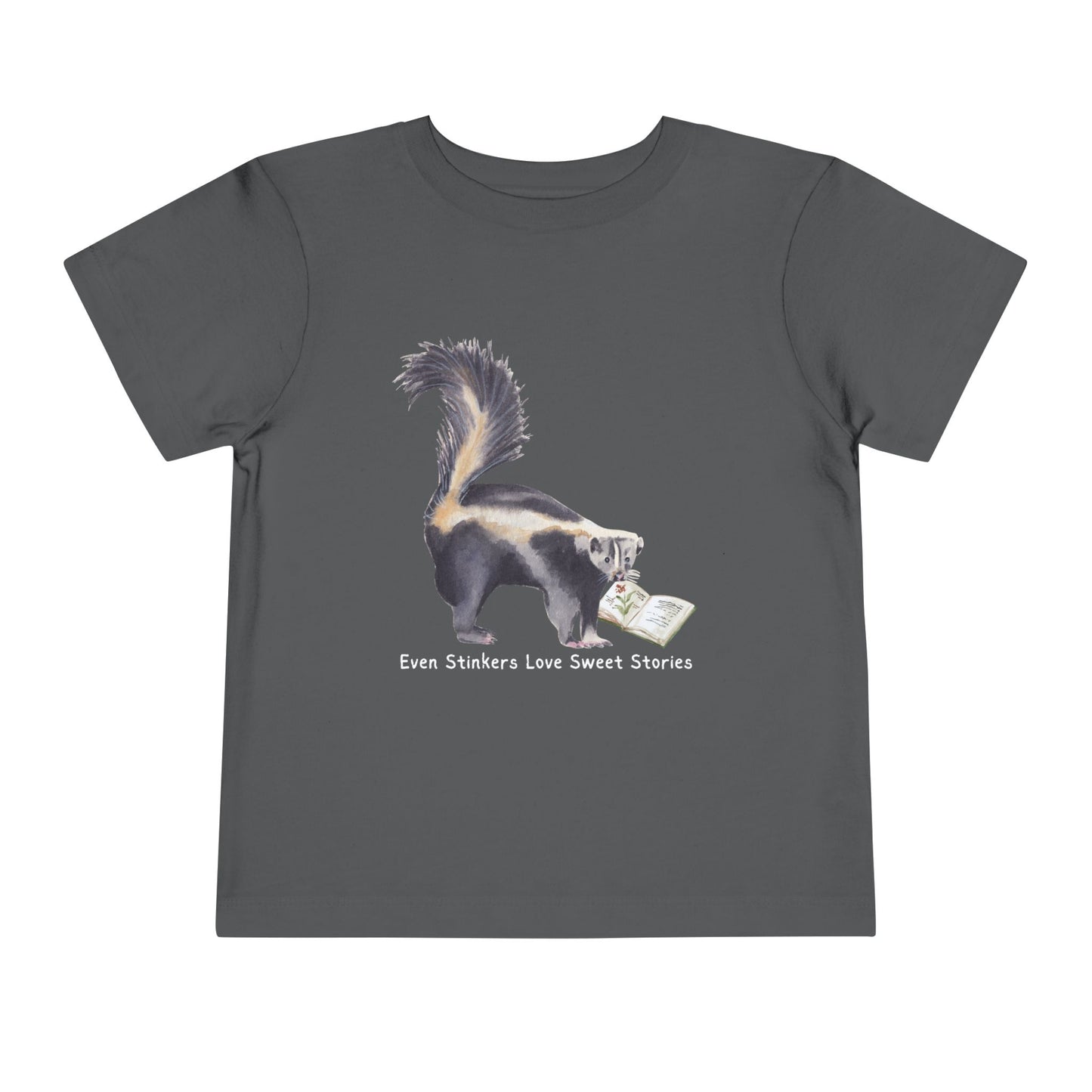Gray toddler t-shirt with a skunk reading a book and text 'Even Stinkers Love Sweet Stories' 