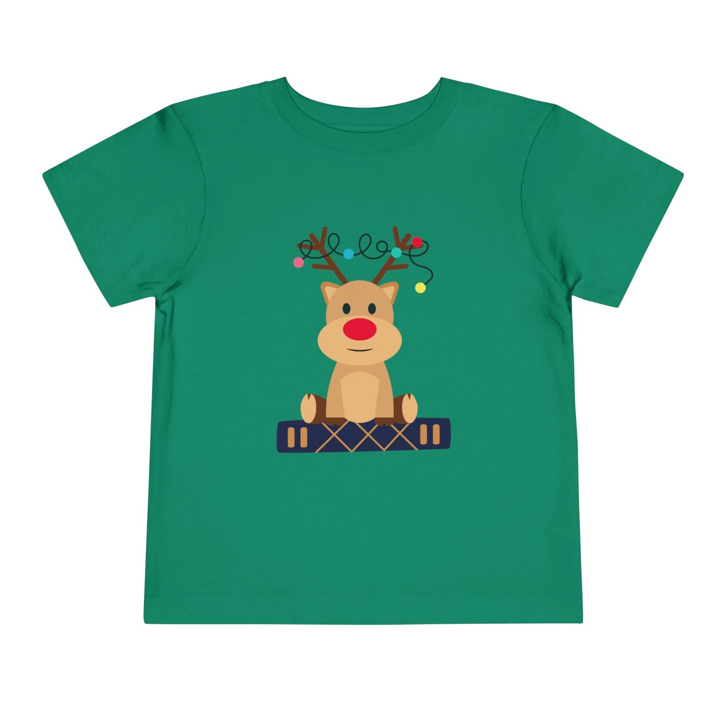 Green toddler t-shirt with a baby reindeer sitting on a book, a string of Christmas lights in it's antlers, on a white background
