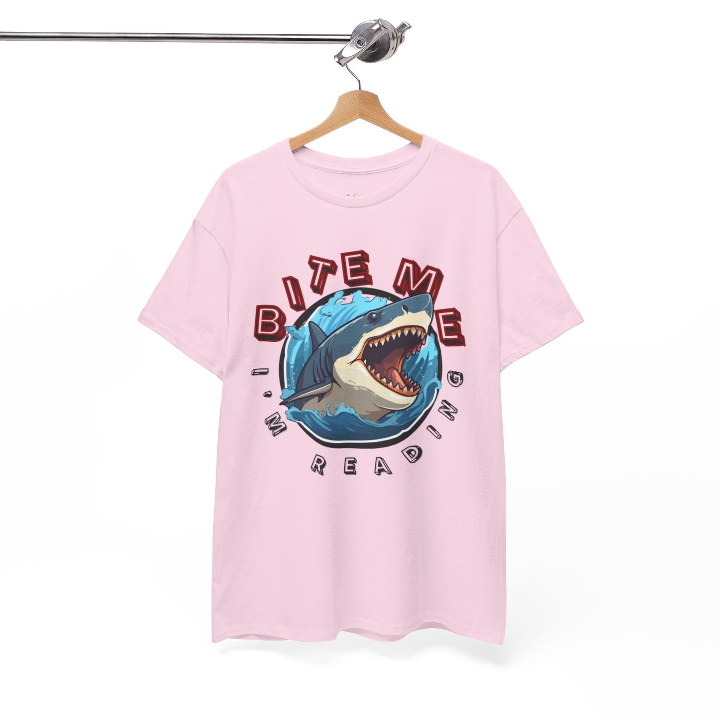 Light pink t-shirt with a shark graphic bursting out of the center and text 'Bite Me I'm Reading' 