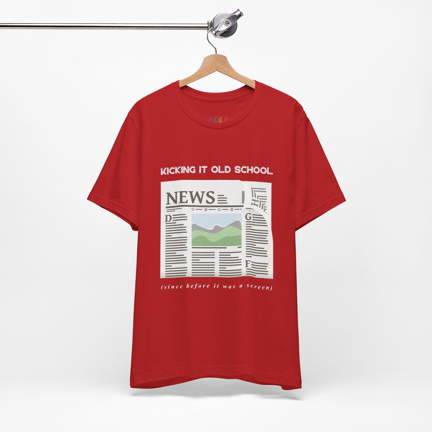 Red t-shirt with a newspaper graphic and text 'Kicking It Old School (since before it was a screen)'