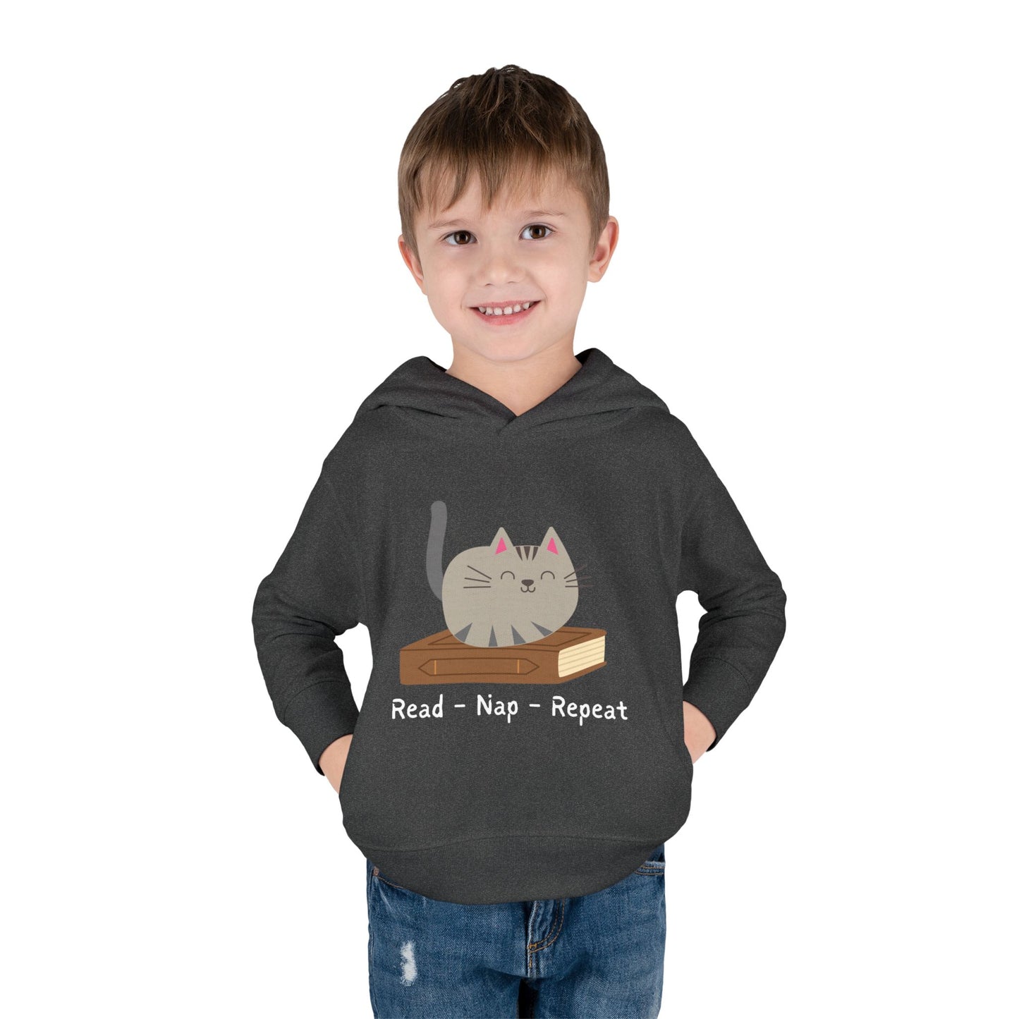 Boy wearing a dark gray toddler hoodie featuring a gray cat laying on a book and text 'Read - Nap - Repeat' on a white background