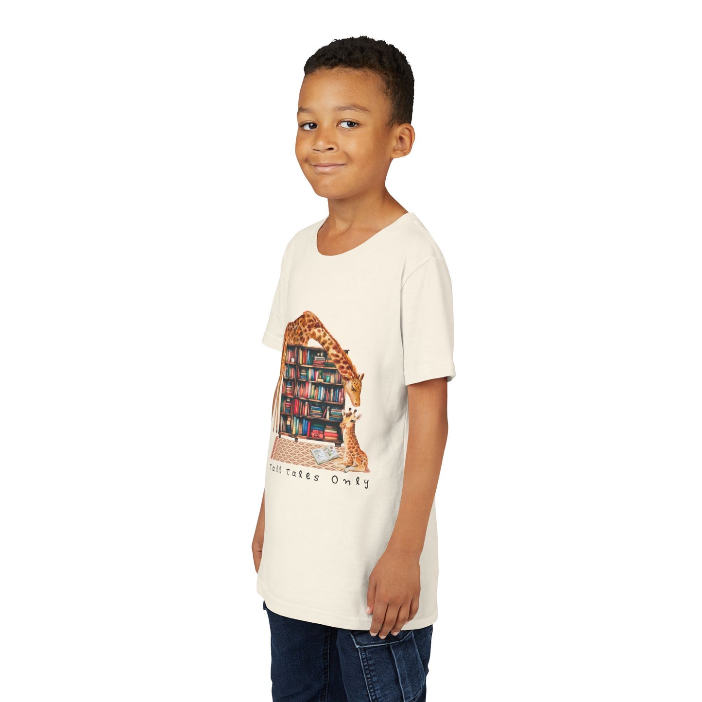 Boy wearing a beige t-shirt with a graphic of giraffes in a library and 'Talk Tales Only' text 