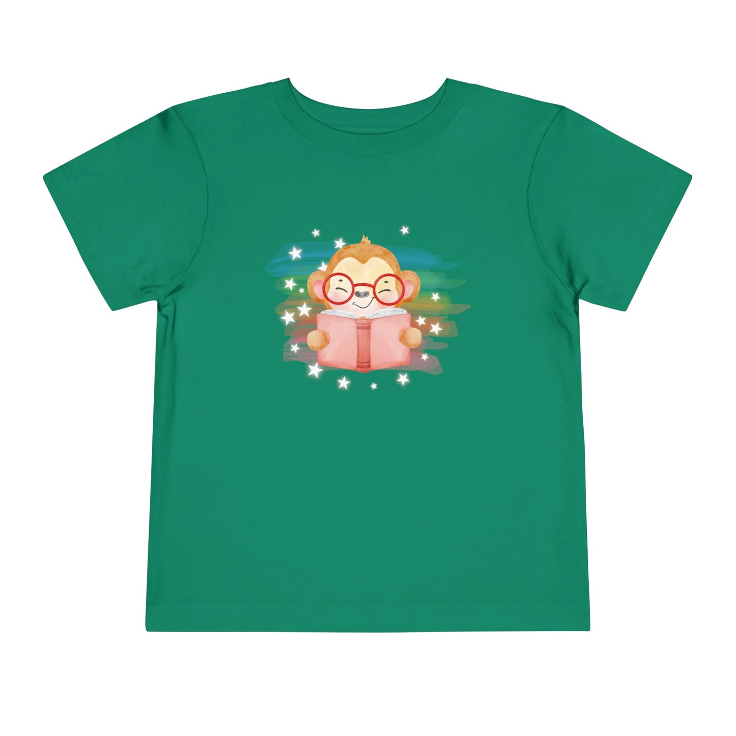 Green t-shirt with a cartoon monkey reading a book, lit up by rainbow watercolor rainbow and stars