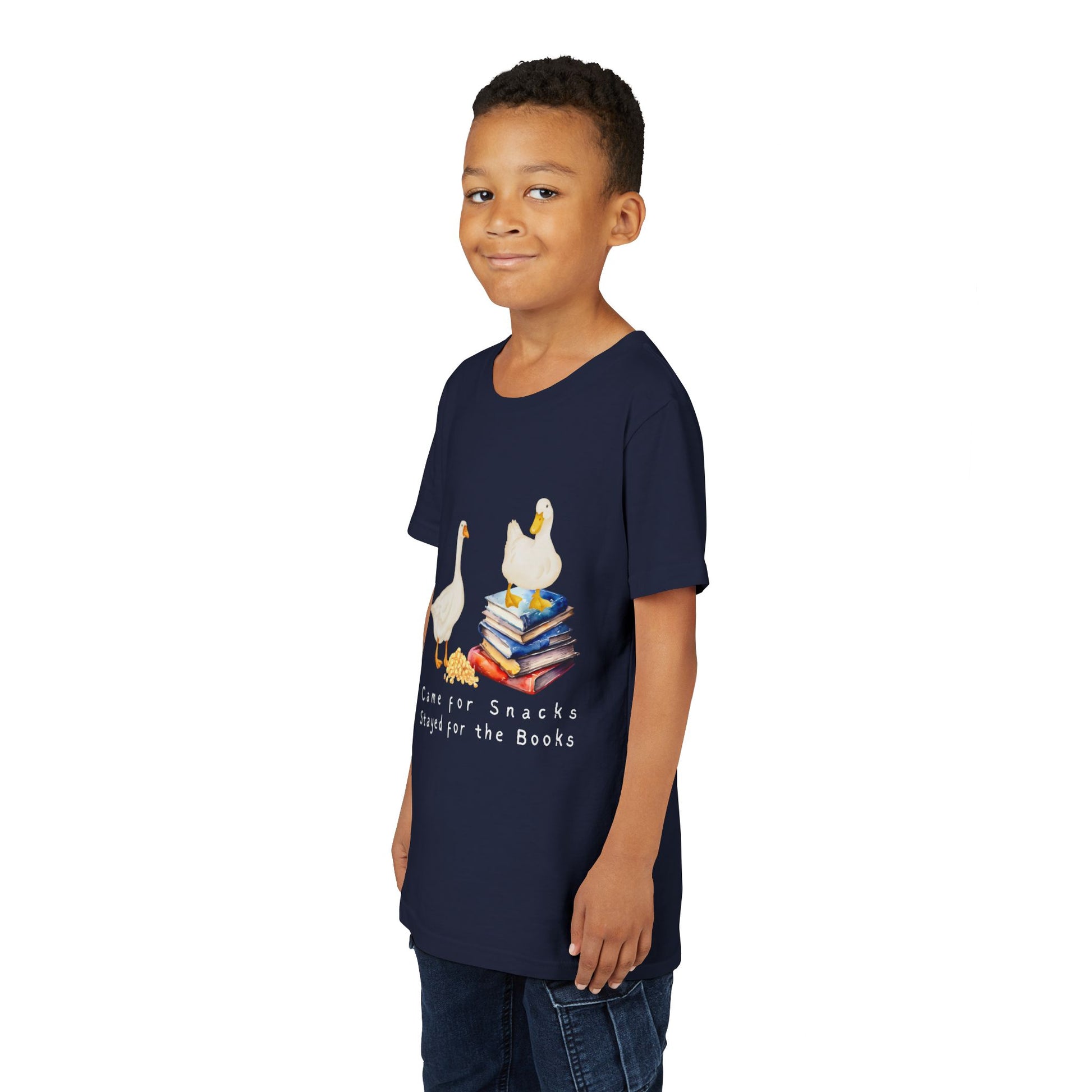 Boy wearing a navy blue t-shirt with cartoon ducks, snacks, books and text 'Came For Snacks Stayed For The Books'