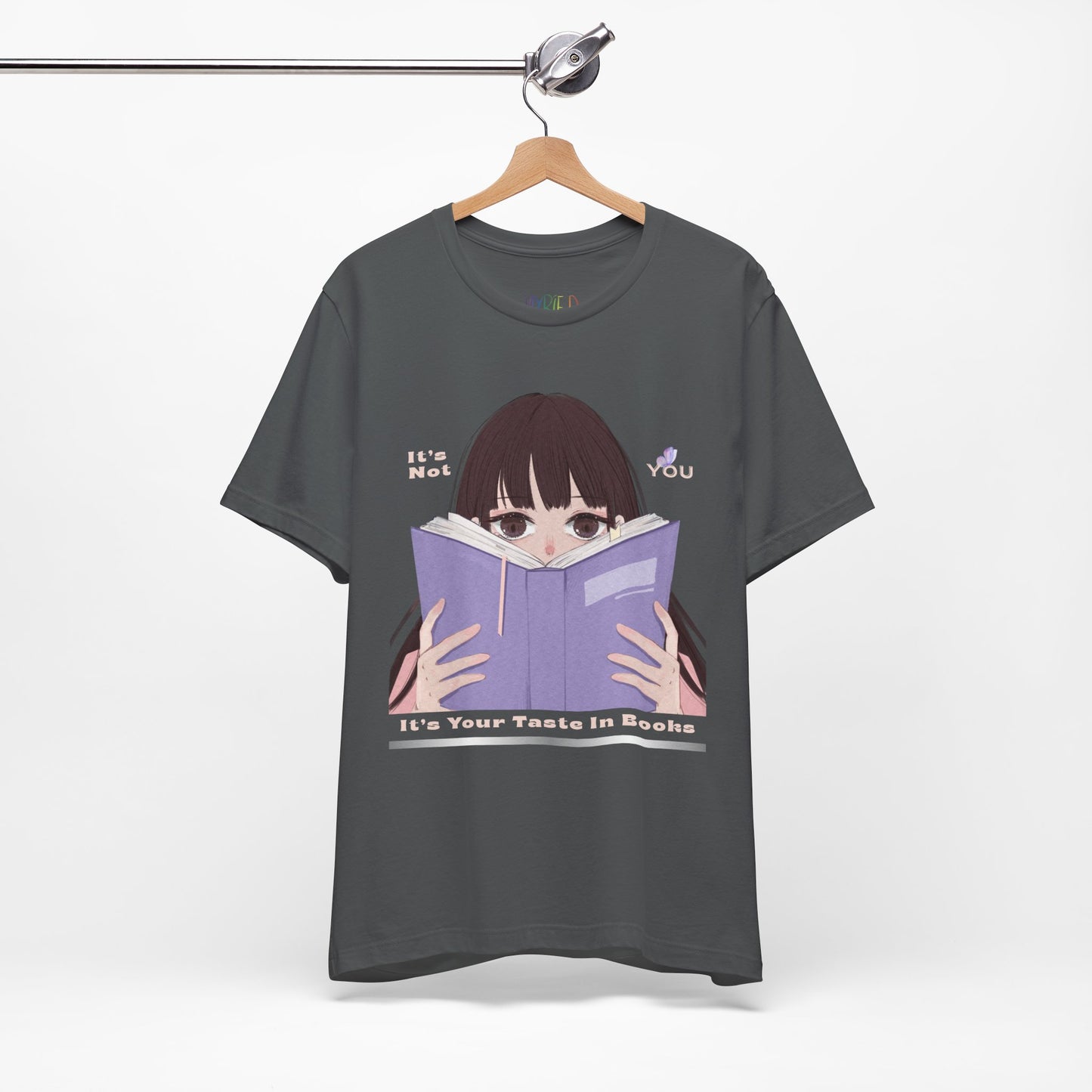 Gray t-shirt with graphic design of a girl peeking over the top of a book and text 'It's Not You. It's Your Taste In Books.'