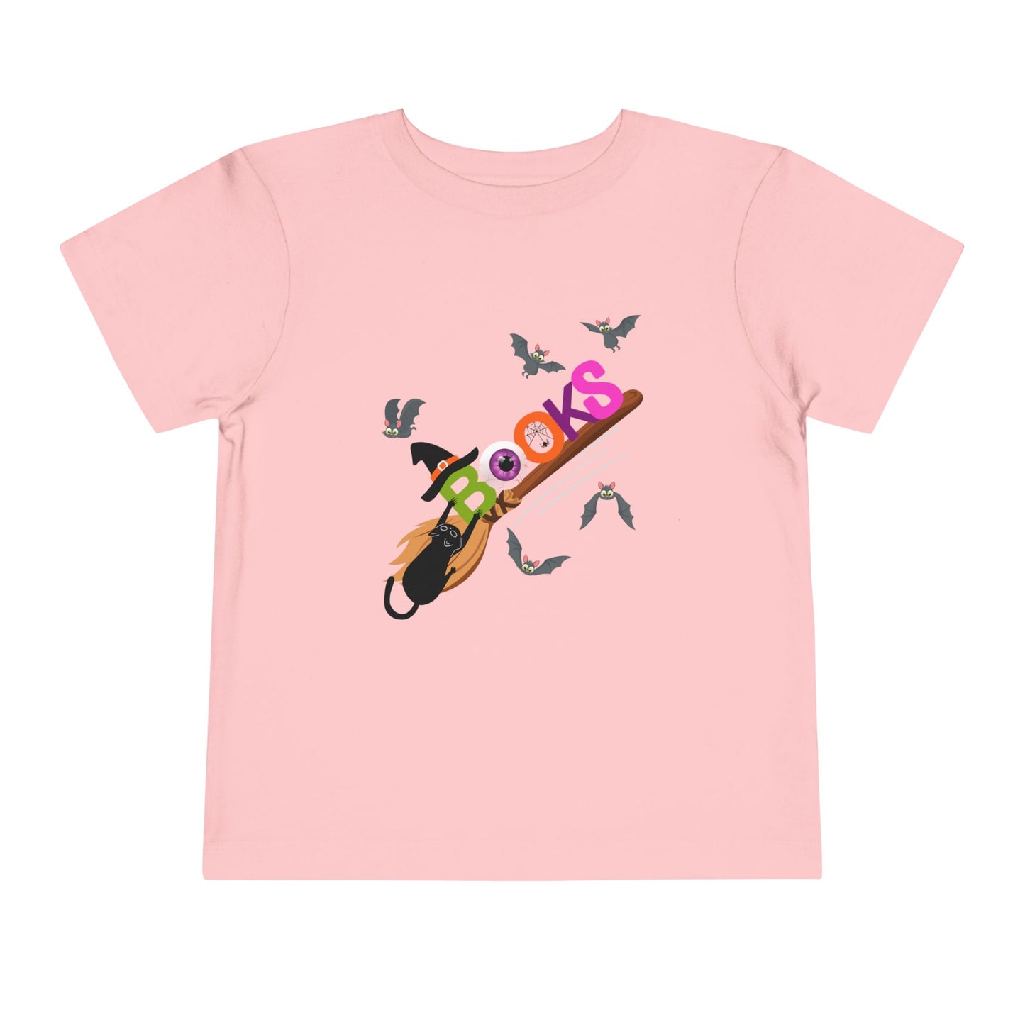 Pink toddler t-shirt with colorful graphic design of 'BOOKS' riding a broom with a black cat barely handing on and bats all around