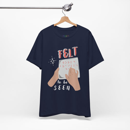 Navy blue t-shirt with graphic design of hands reading braille text and 'Felt To Be Seen' messaging 