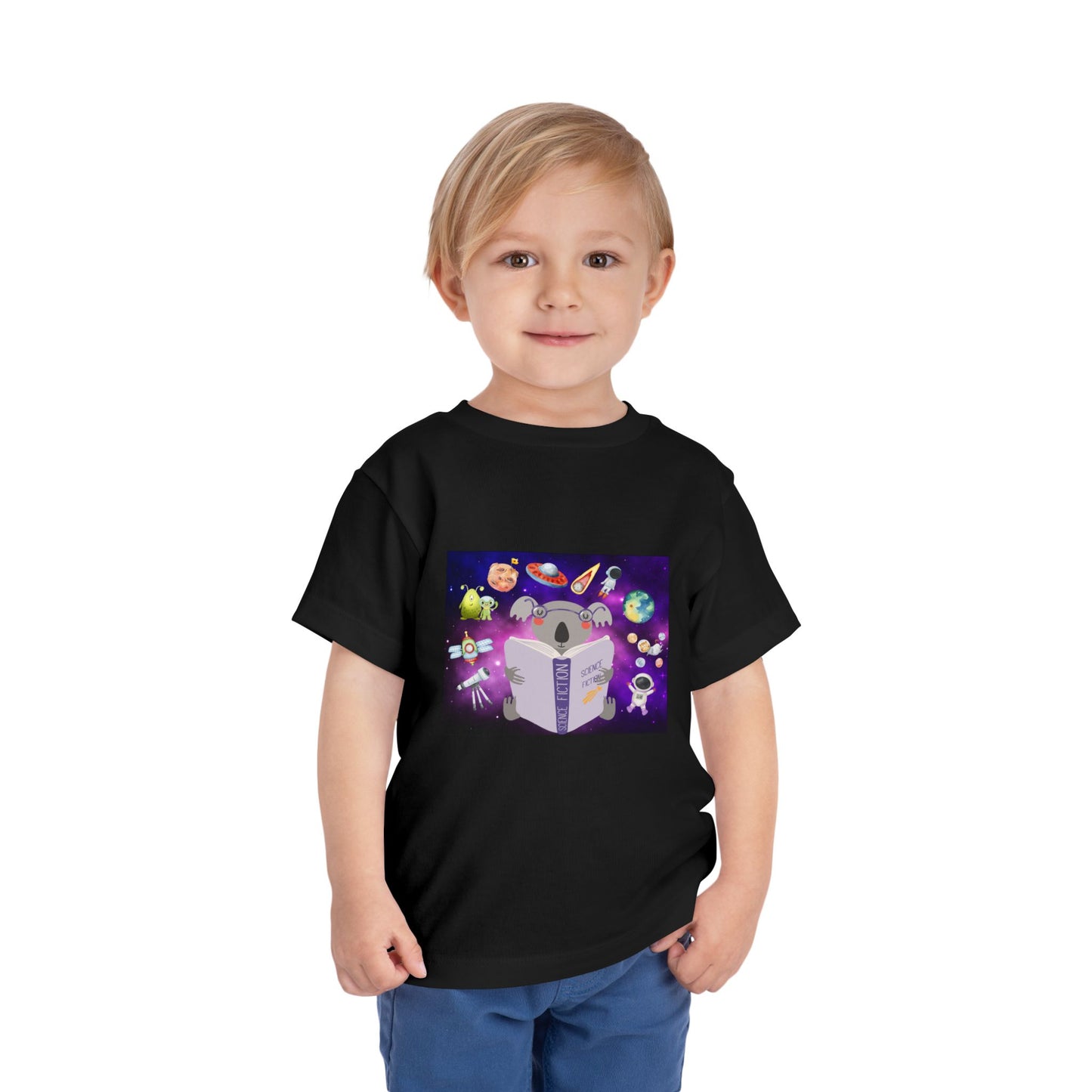 Child wearing a black toddler t-shirt with a colorful graphic of a koala reading a book, with all sorts of space ideas floating around 