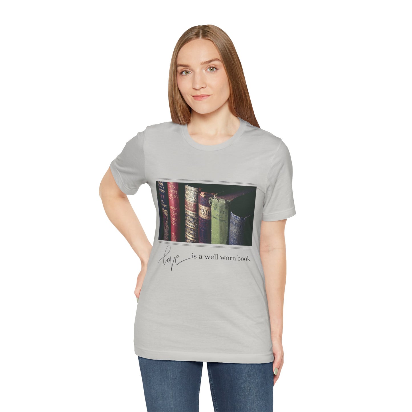 Woman wearing a gray t-shirt with a row of old books and text 'Love Is A Well Worn Book'