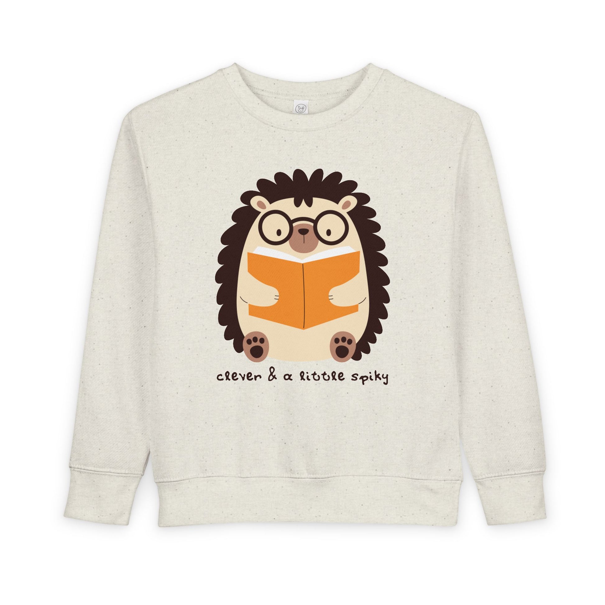 Beige toddler sweatshirt with a hedgehog graphic reading a book and text 'clever & a little spiky'