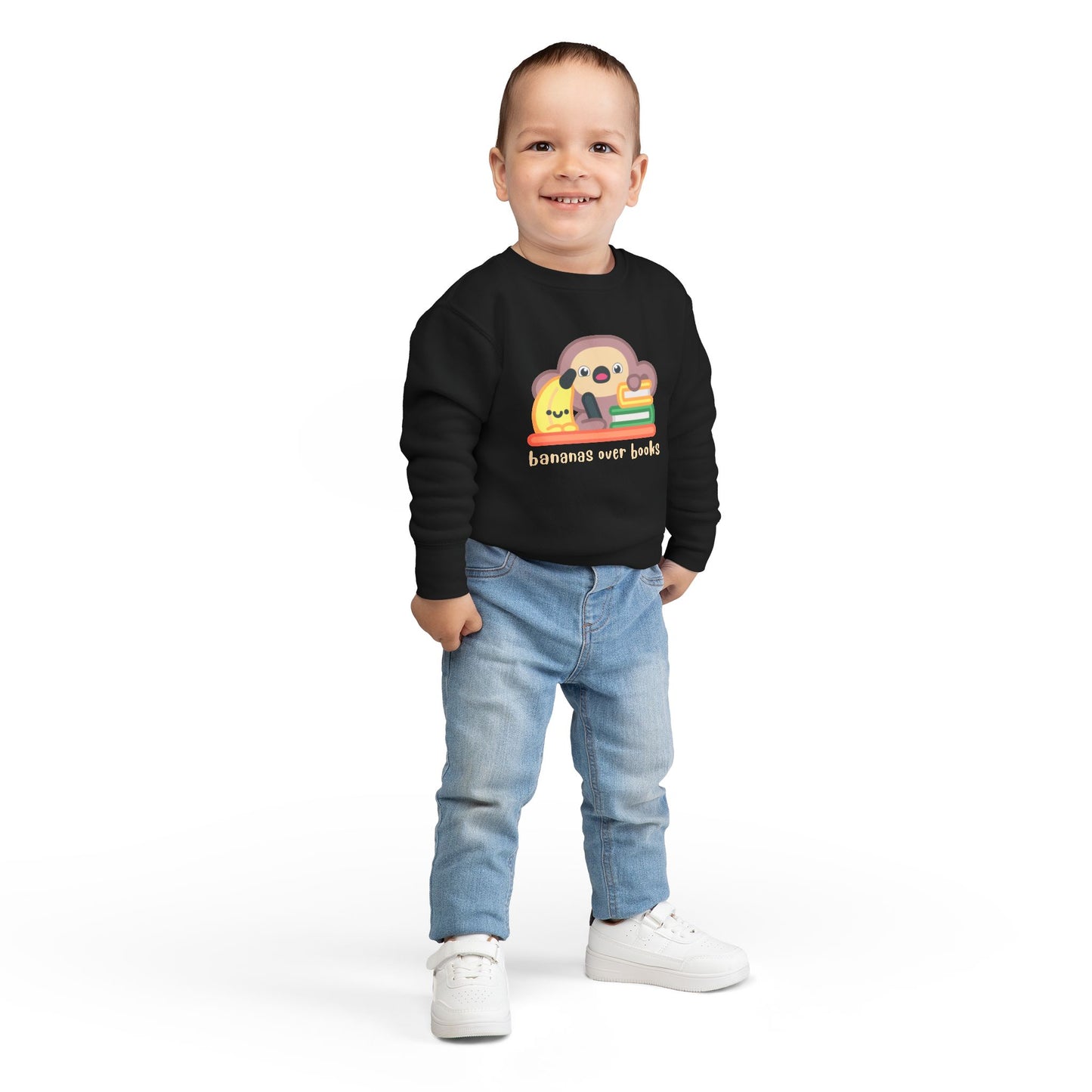 Boy wearing a black toddler sweatshirt with a cartoon monkey and banana writing desk design 
