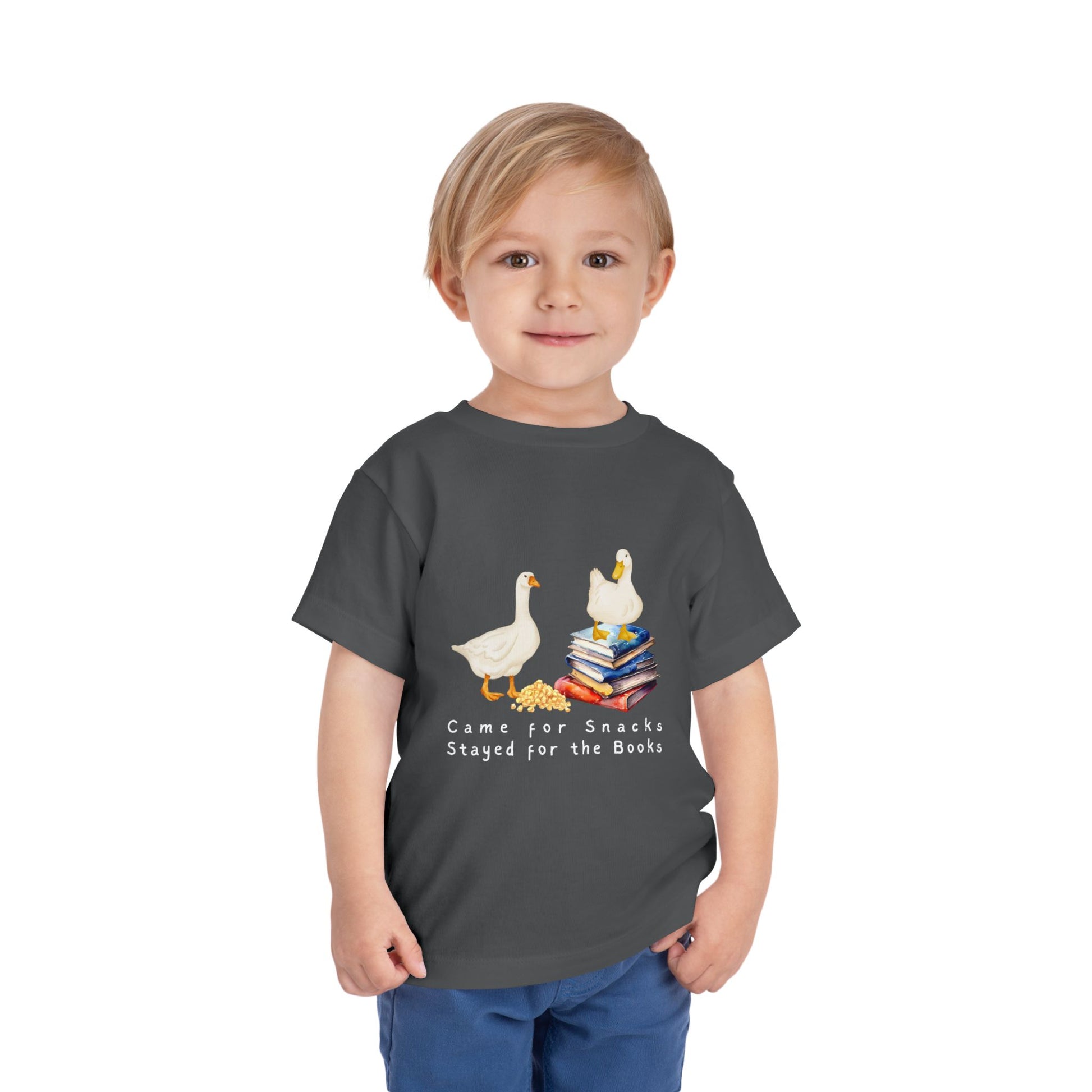 Child wearing a gray toddler t-shirt with cartoon ducks, books and text 'Came for Snacks, Stayed for the Books'