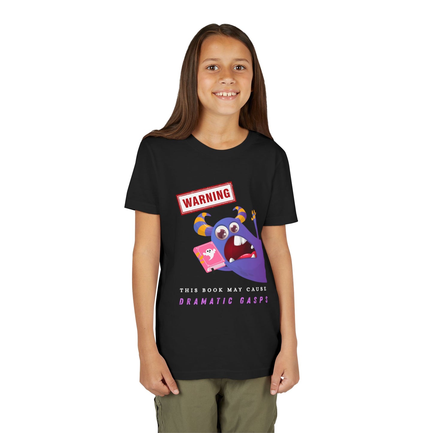 Girl wearing a black t-shirt with a purple monster urgently leaning in with a ghost book, a WARNING sign overhead, and text below 'This Book May Cause Dramatic Gasps'