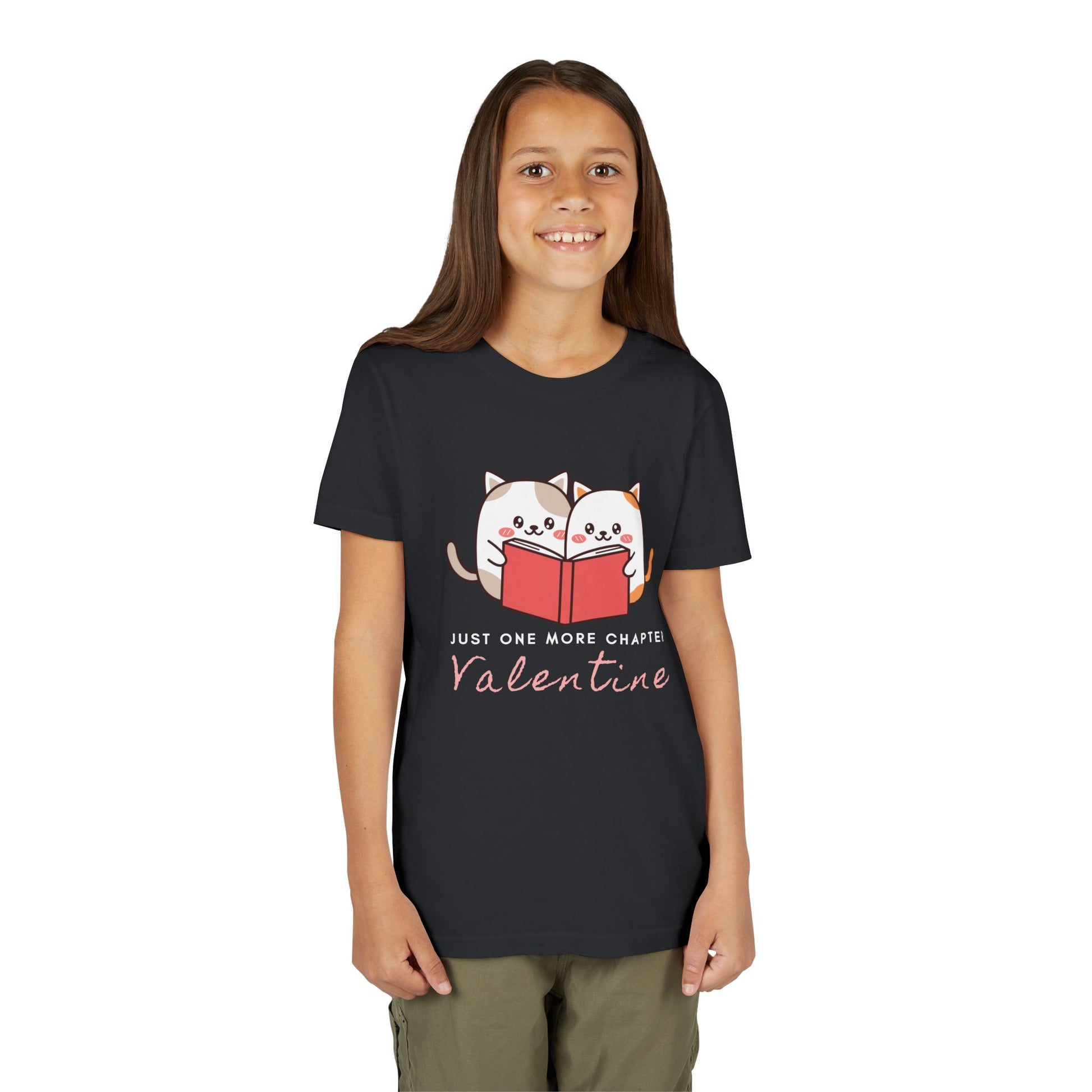 Girl wearing a black t-shirt with two cartoon cats reading a book and 'Just One More Chapter Valentine' text 