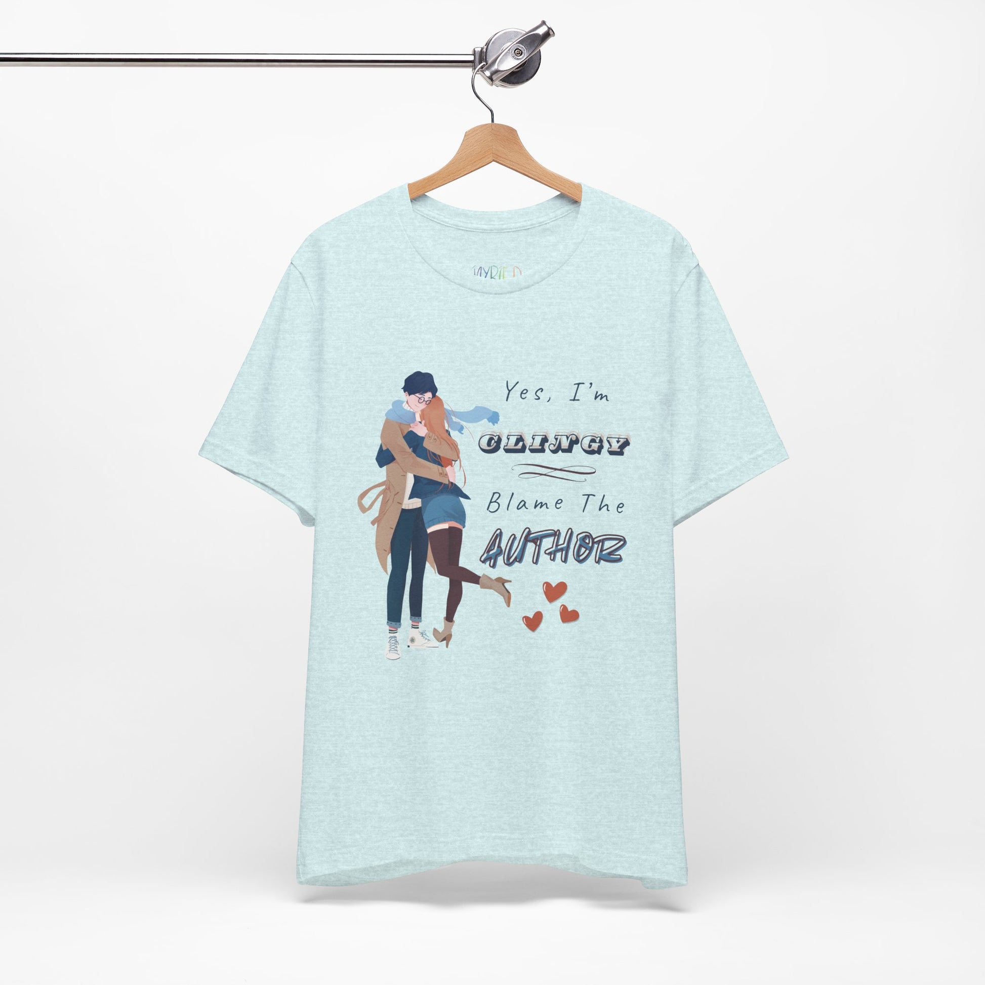Icy blue t-shirt with graphic design of a woman snuggled up to a man and text " and text on a white background 'Yes, I'm CLINGY. Blame The Author.'