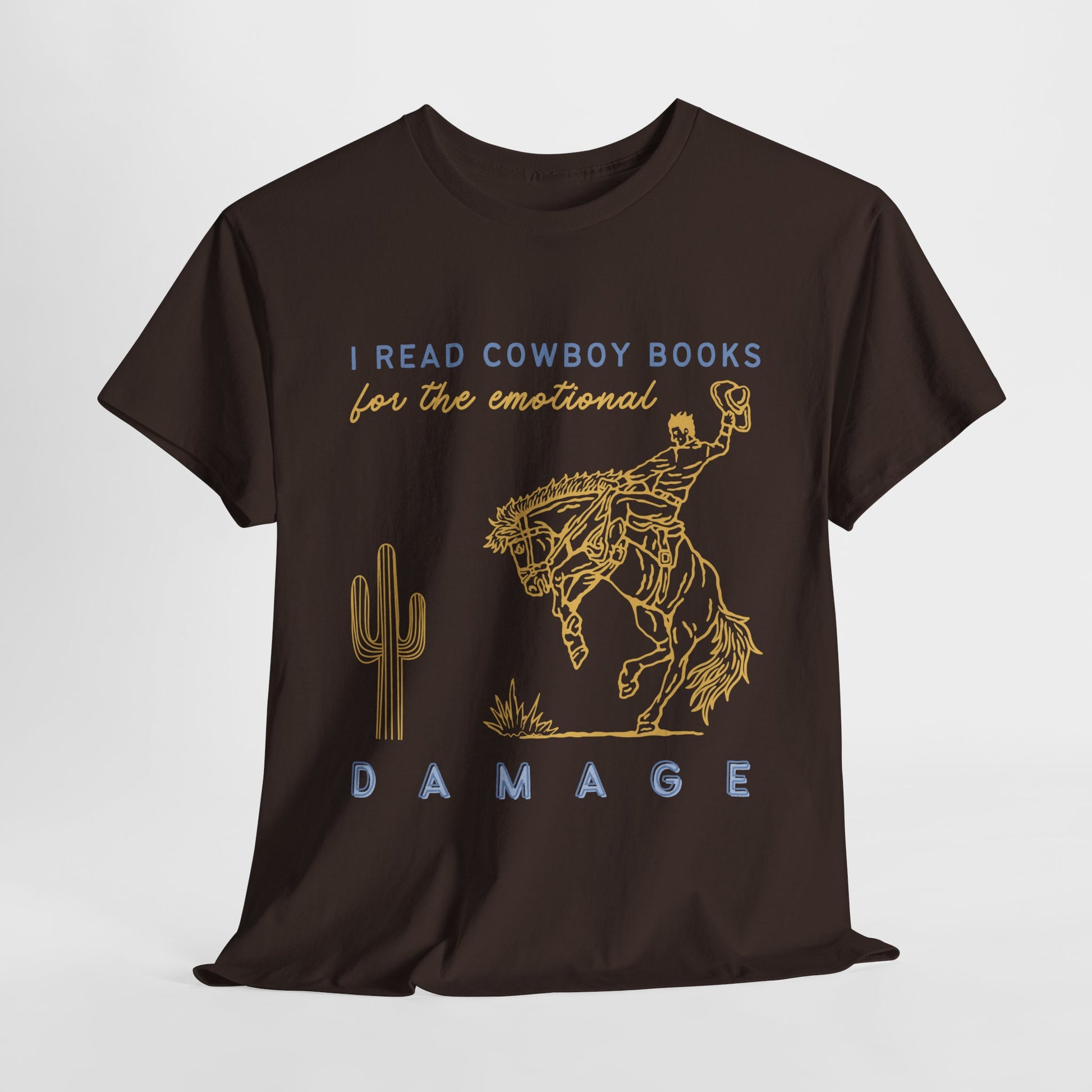 Brown t-shirt with cowboy on a bucking bronco in a desert scene, blue and beige text 'I READ COWBOY BOOKS FOR THE EMOTIONAL DAMAGE' 