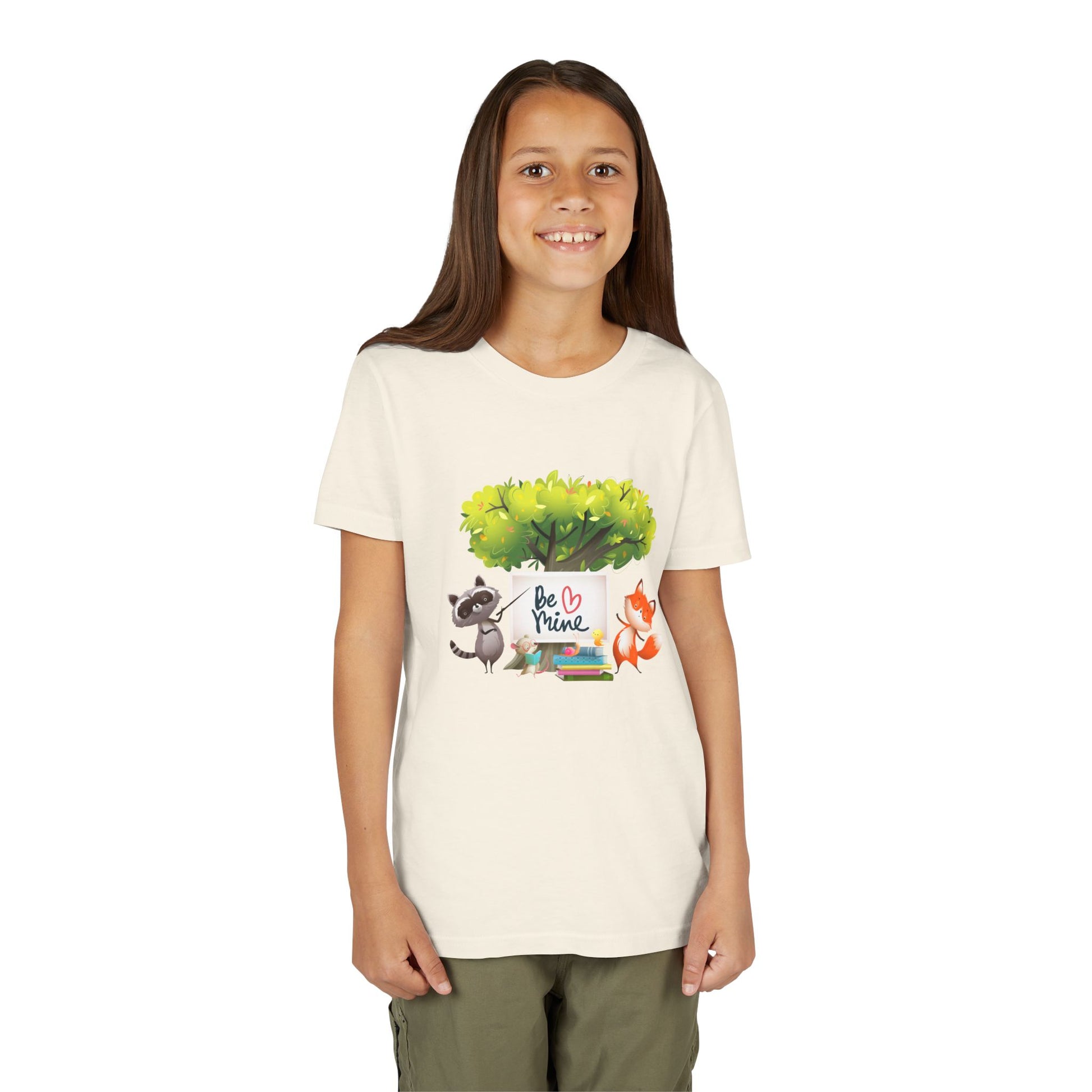 Girl wearing a beige t-shirt with a raccoon and fox graphic and 'Be Mine' text 