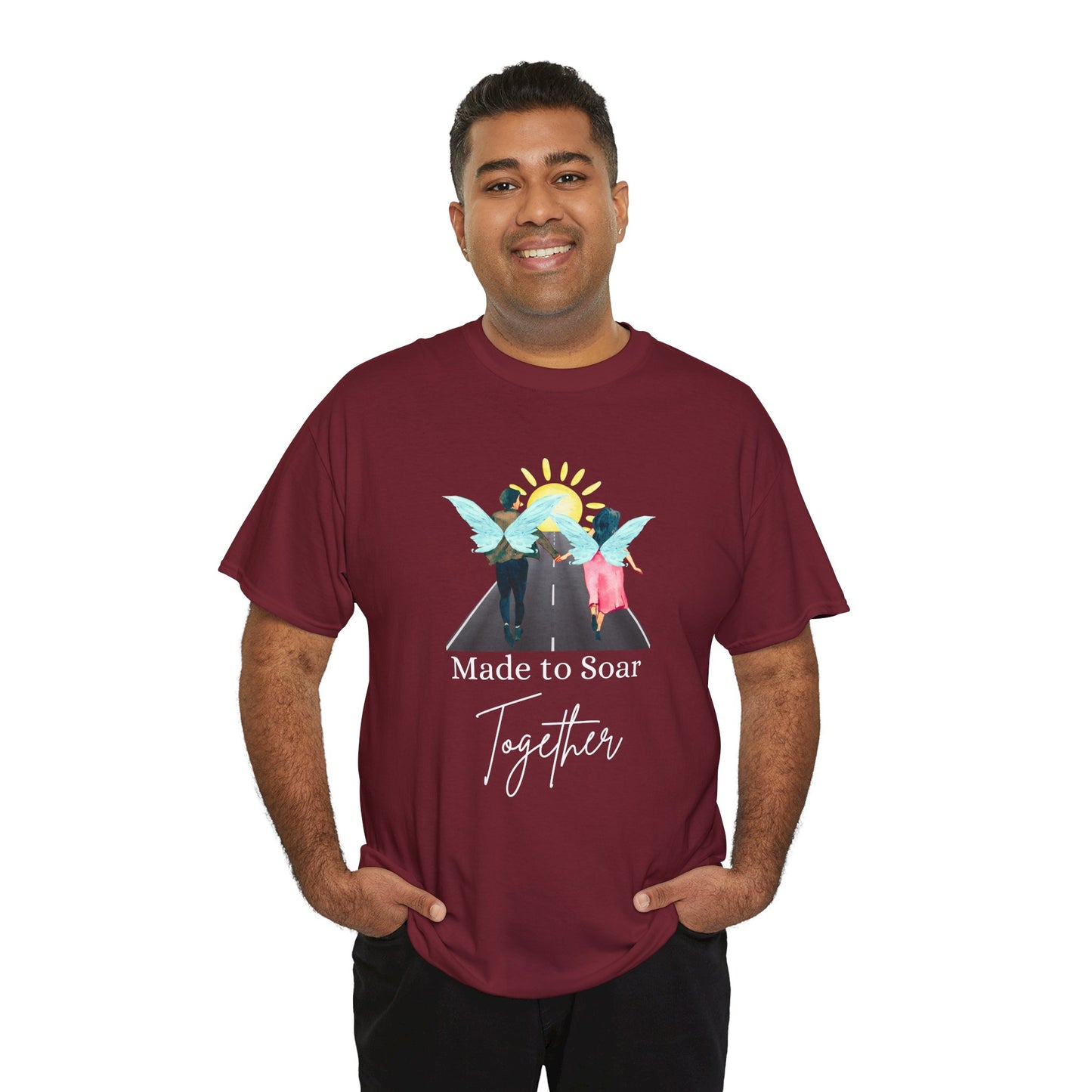 Man waring a maroon t-shirt with graphic design of two fairies running down the toward toward the sunset and text 'Made To Soar Together' and text 'Made to Soar Together' 